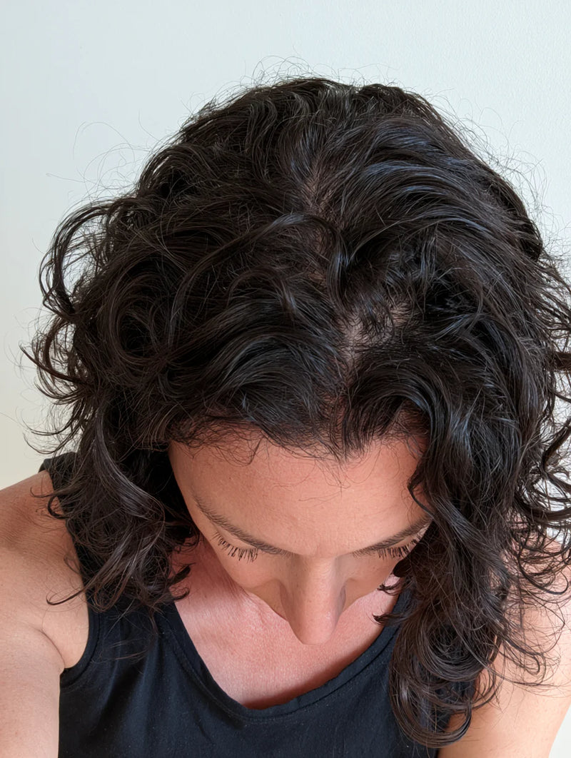 Mujer mostrando la densidad de su cabello rizado desde arriba